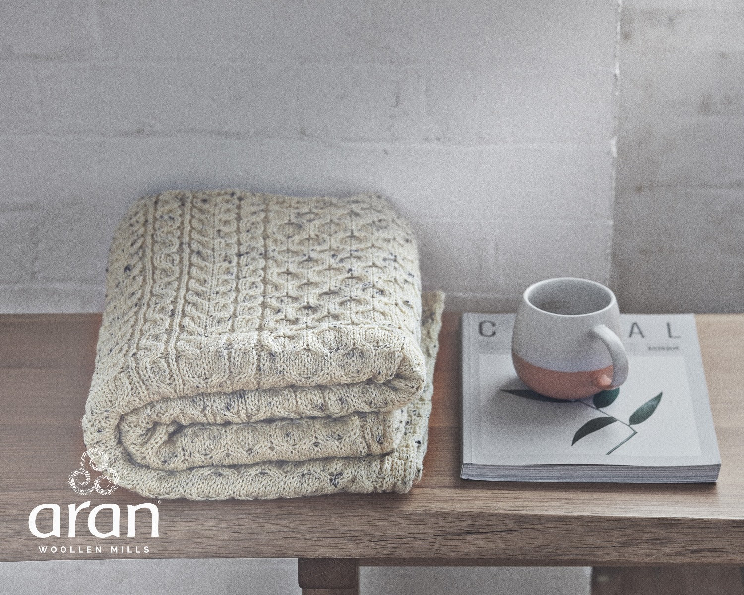 Woman modelling Aran Woollen Mills honeycomb blanket