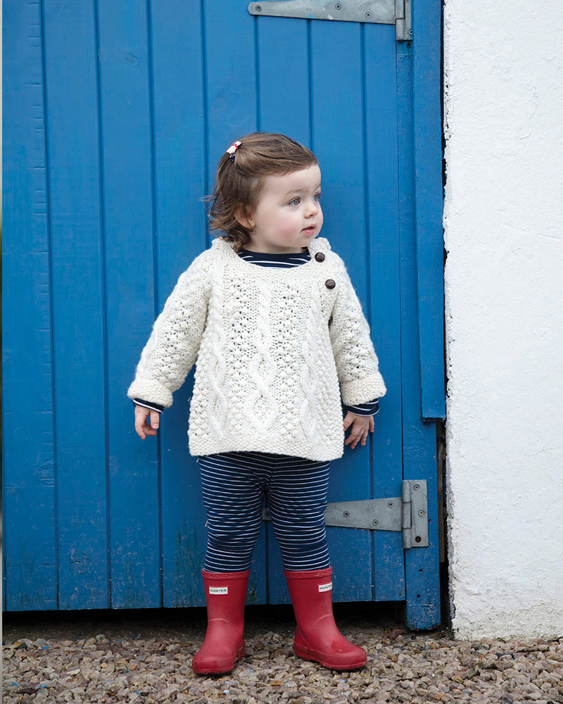 Baby modelling Aran Woolen Mills baby hoodie in natural